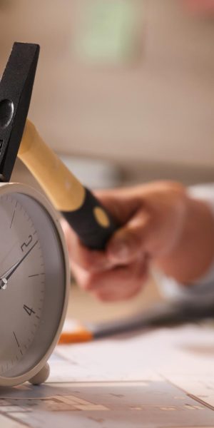 close-up-businesswoman-hitting-clock-her-desk-while-working-office
